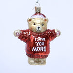 Glass bear ornament wearing a red sweater with 'I love you more' text on a white background
