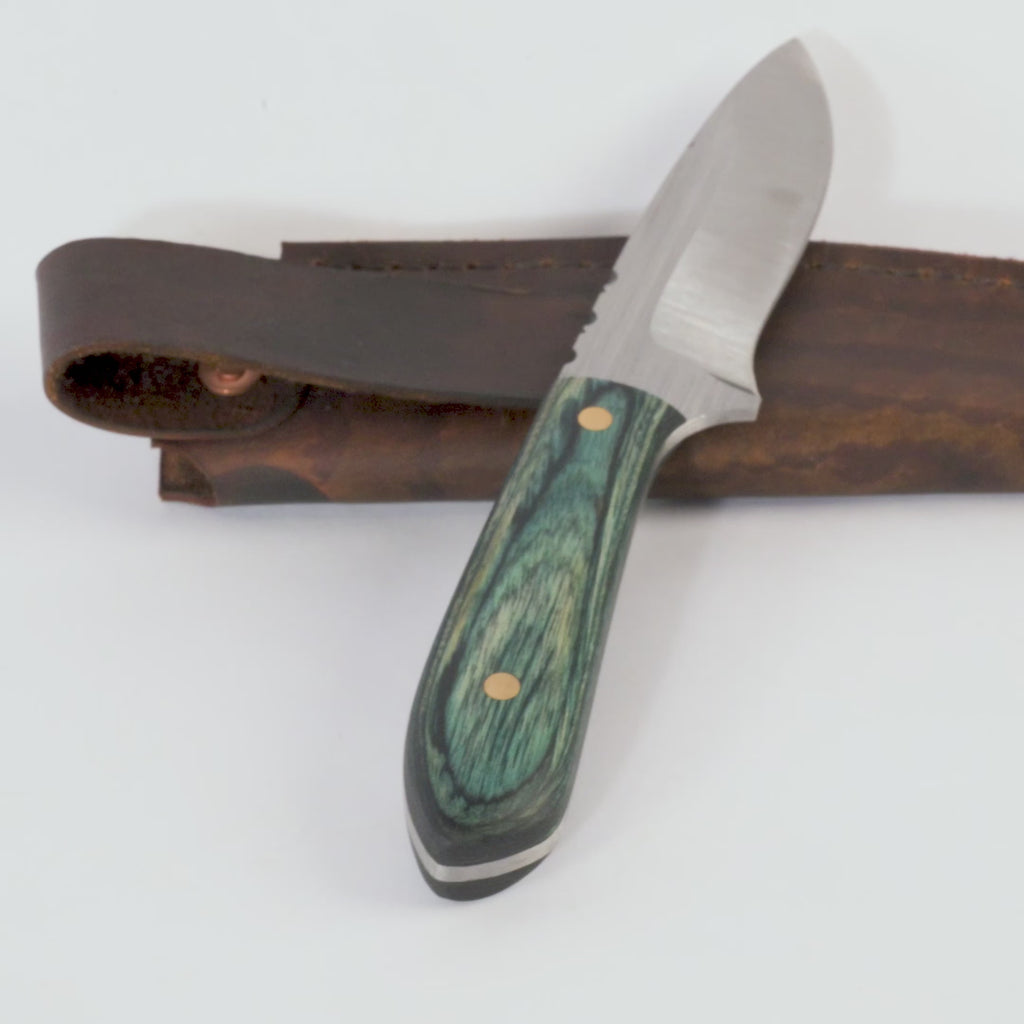 hand crafted knife with wooden handle and leather sheath on white background