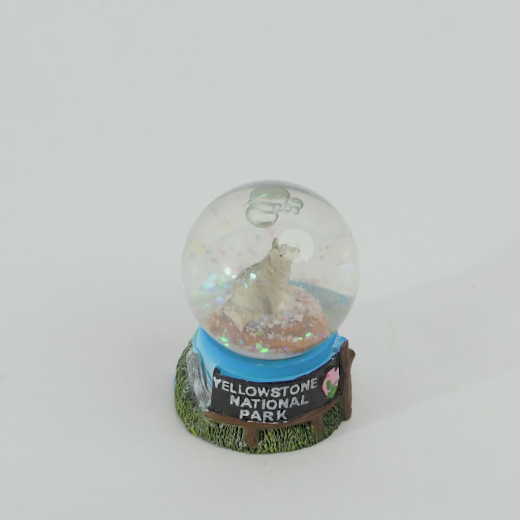 Snow globe with wolf design and 'Yellowstone National Park' base on a white background