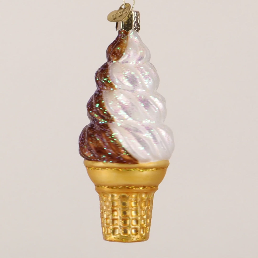 Decorative glass ice cream cone ornament with brown and white swirls on a white background