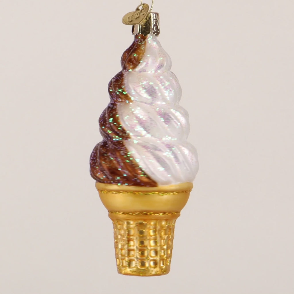 Decorative glass ice cream cone ornament with brown and white swirls on a white background