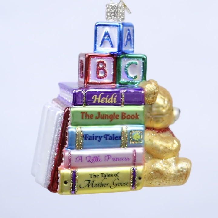 Decorative ornament with books and a teddy bear on a white background