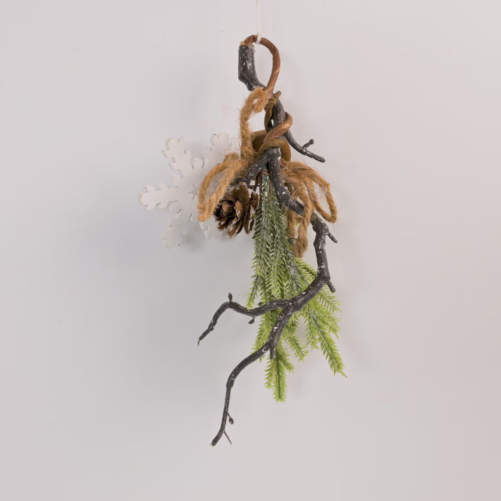 Decorative branch with greenery and brown twine on a light gray 