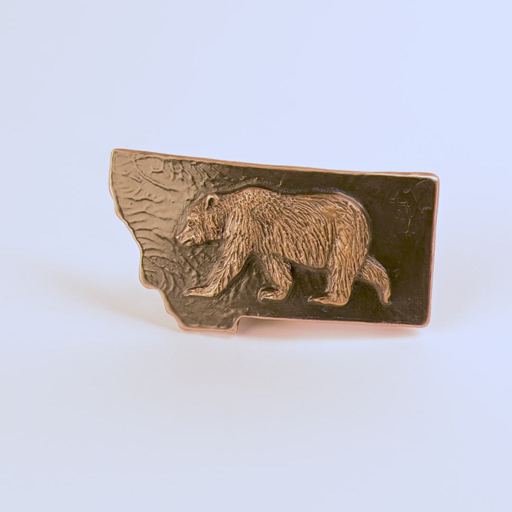 Metallic bear emblem belt buckle on a black background