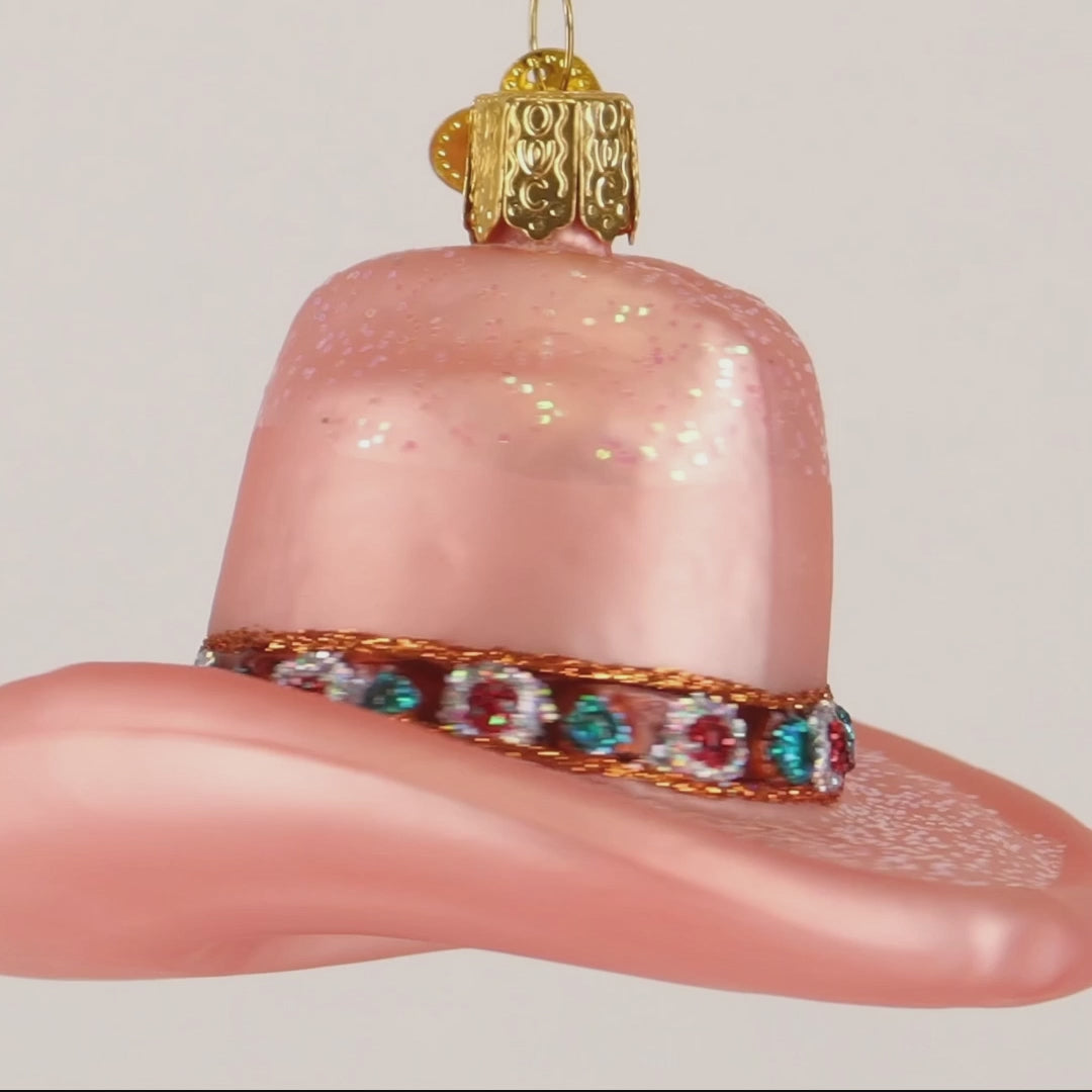 Pink cowboy hat ornament with gemstone band on a white background