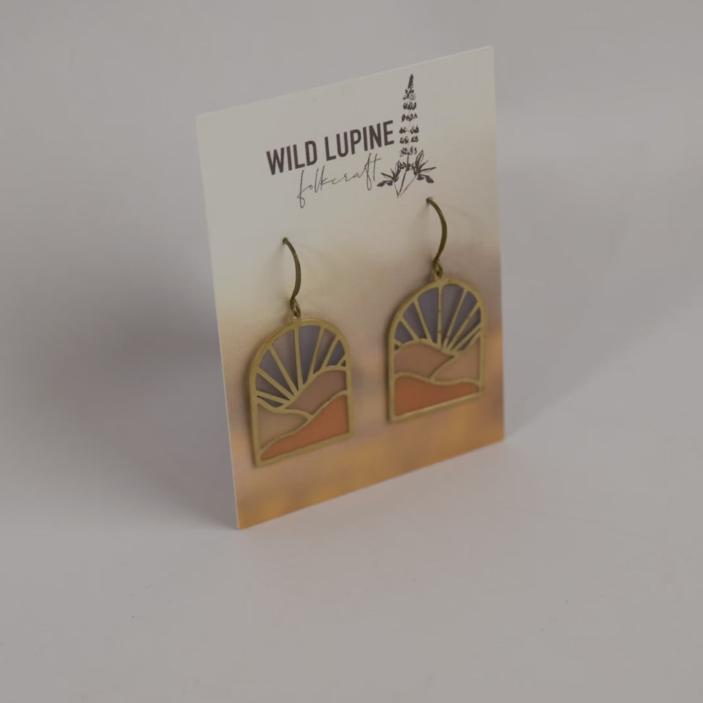 Pair of earrings on a 'Wild Lupine Folkcraft' branded card.