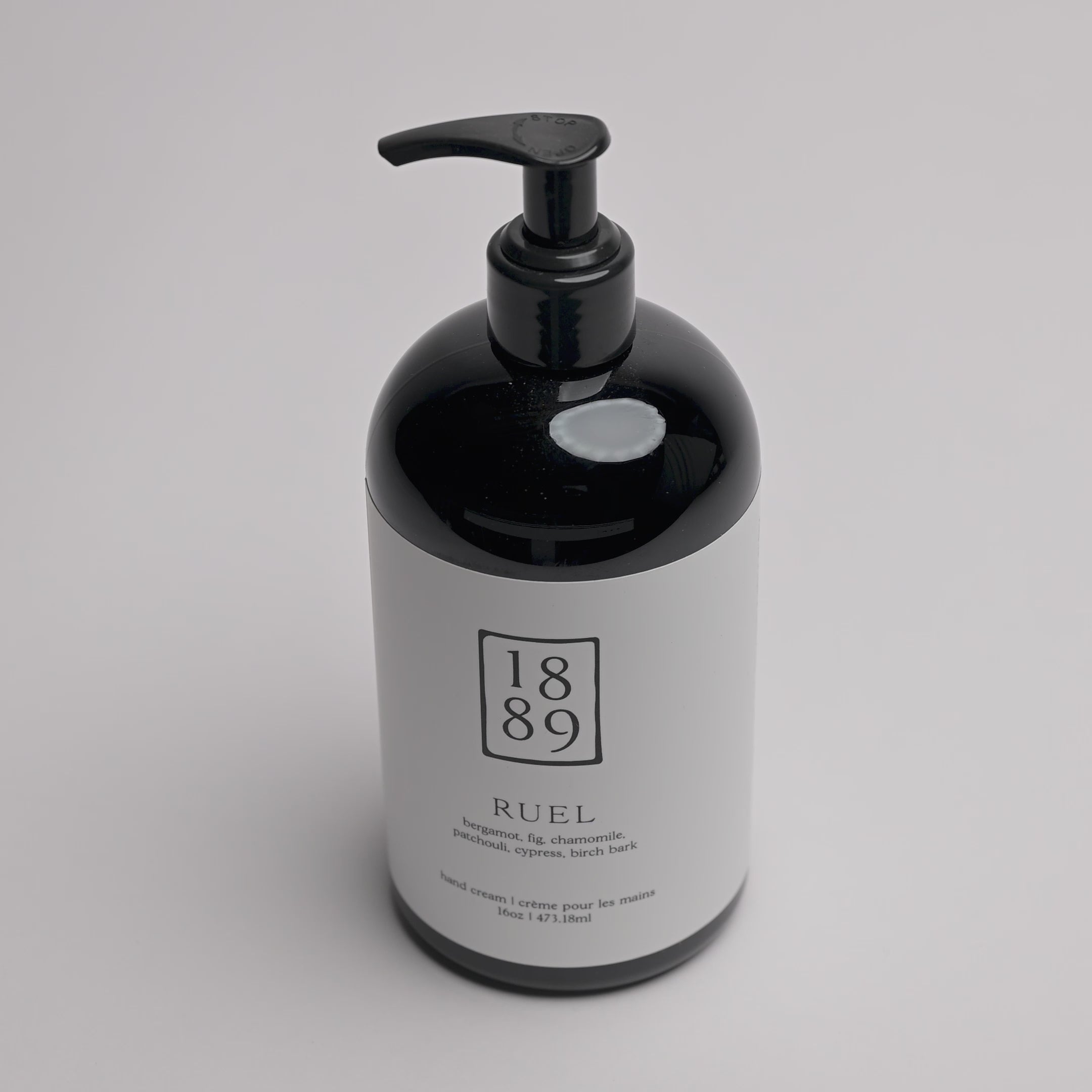 A black pump bottle of RUEL hand cream with a white label, photographed on a clean white background.