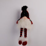 Plush gnome toy with red and black checkered hat and striped socks on a white background