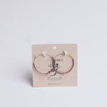 Two hoop earrings on a Lady Bird branded card with a white background