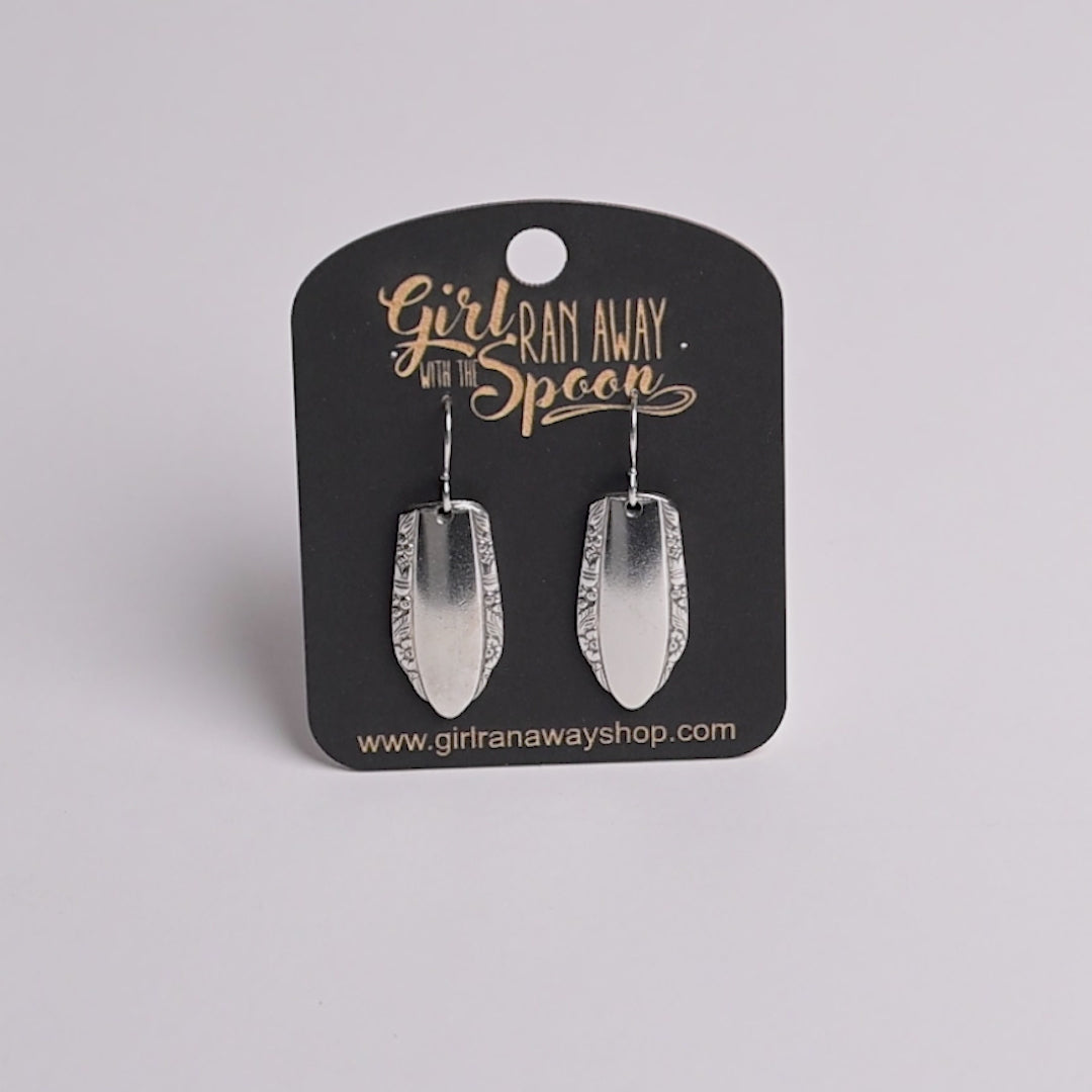 Silver earrings on a 'Girl Run Away with the Spoon' branded card.