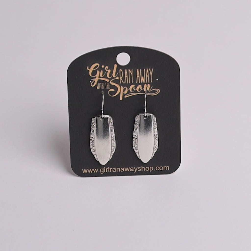 Silver earrings on a 'Girl Run Away with the Spoon' branded card.
