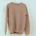 Brown sweatshirt with 'Montana' logo on a hanger against a white 