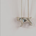 Silver bobcat-shaped pendant on a chain against a white background