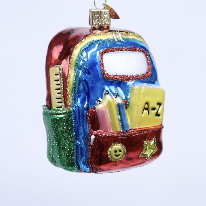 Colorful backpack ornament with stationery items on a white background