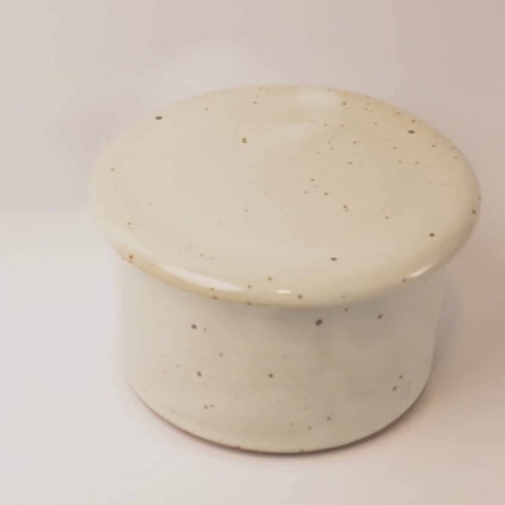 Speckled ceramic container on a white background