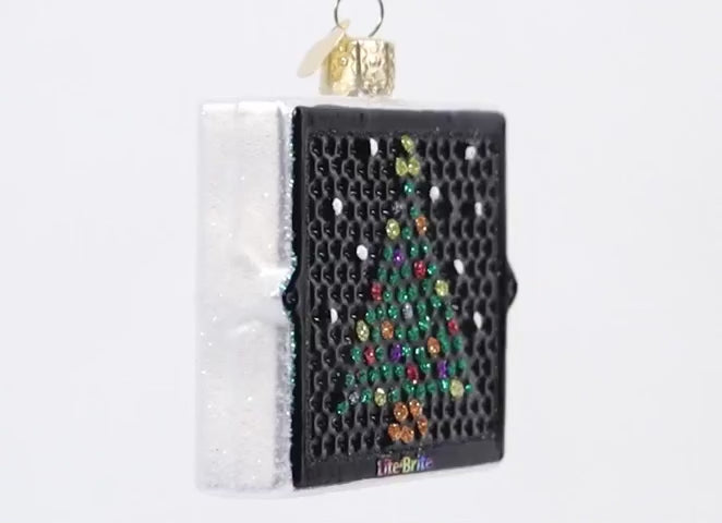 Decorative ornament shaped like a Lite-Brite with a Christmas tree design on a white background