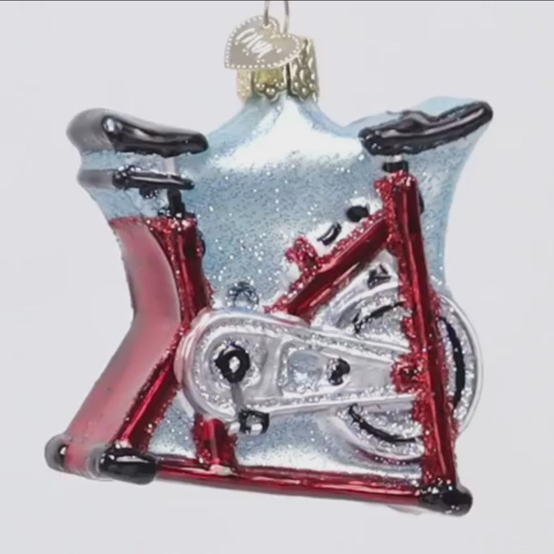 Glass ornament shaped like a bicycle with a red frame white background