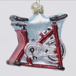 Glass ornament shaped like a bicycle with a red frame white background