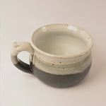 Ceramic bowl with speckled glaze on a white background