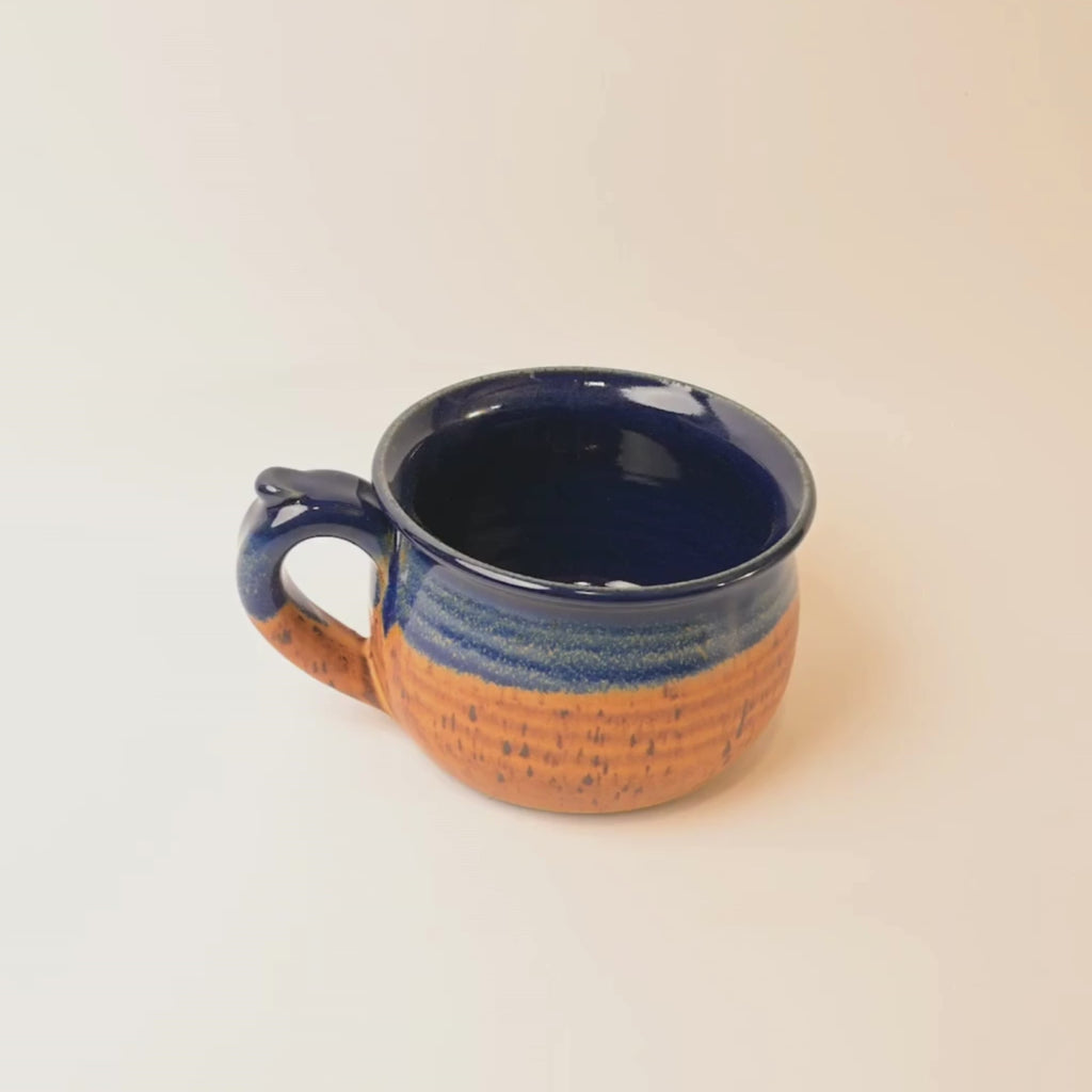 Ceramic mug with blue and brown glaze on a white background