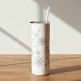 White tumbler with snowflake patterns on a wooden surface