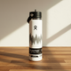 White Hydro Flask water bottle with black lid on a wooden surface