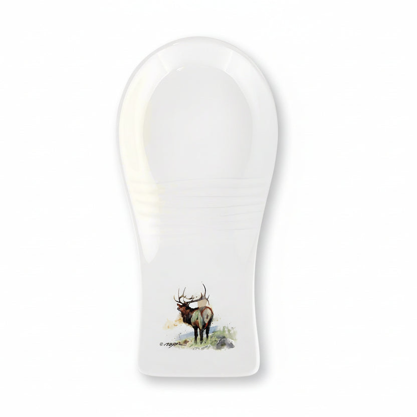 A white stoneware spoon rest with a detailed watercolor illustration of an elk at the base.