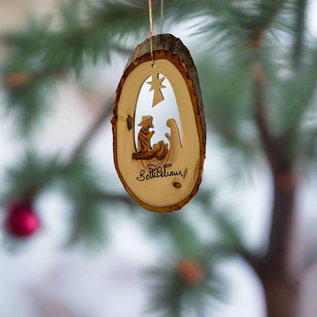 Carved within olive wood that is harvested in the Holy Land, this Nativity Natural Cut Ornament by EarthWood features the nativity scene of new born Jesus underneath the Star of Bethlehem.