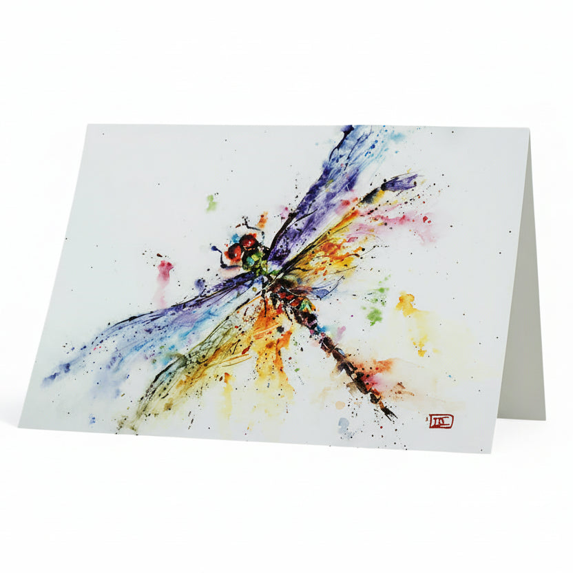 A greeting card featuring a watercolor illustration of a dragonfly with a pond in the background.