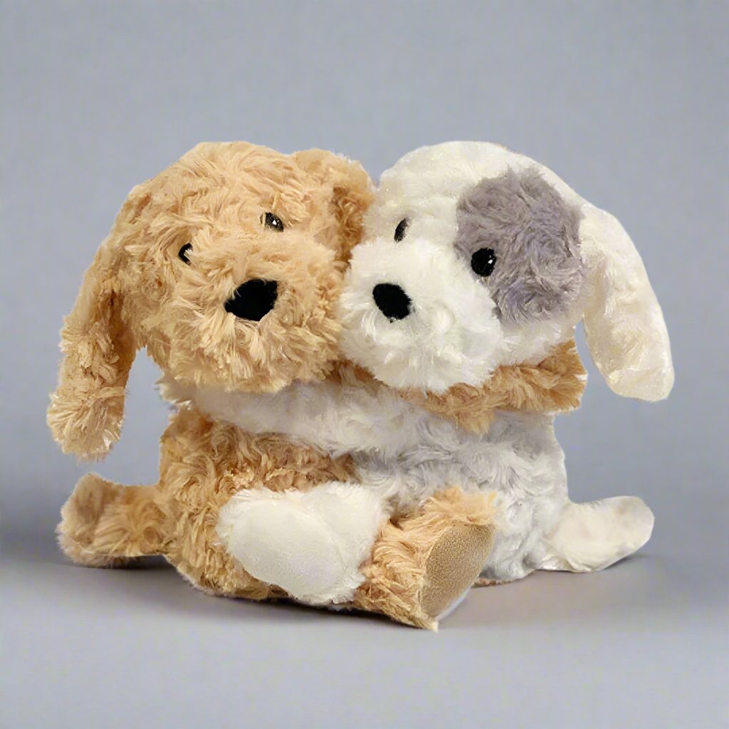 A golden dog and a white dog with one grey spot on the left eye Warmies Hugs made with real lavender