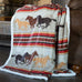 wrangler running horses sherpa throw blanket by carstens features a light grey, red, brown, and light brown stripes and horses with a western pattern